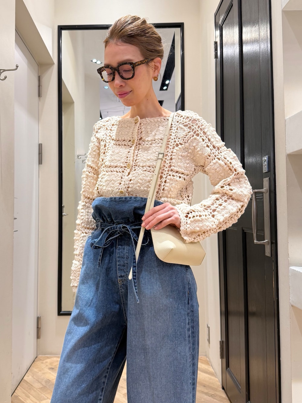 ブルー系のデニムパンツ、ホワイト系のカーディガン/ボレロ、ブラウン系のサンダルを着用したレディースの冬コーディネートの6枚目の写真