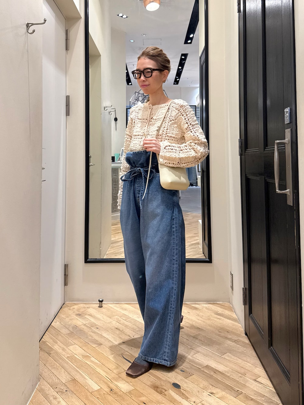 ブルー系のデニムパンツ、ホワイト系のカーディガン/ボレロ、ブラウン系のサンダルを着用したレディースの冬コーディネートの9枚目の写真