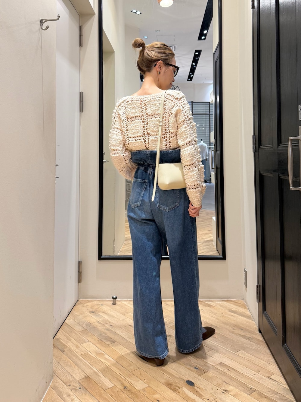 ブルー系のデニムパンツ、ホワイト系のカーディガン/ボレロ、ブラウン系のサンダルを着用したレディースの冬コーディネートの4枚目の写真