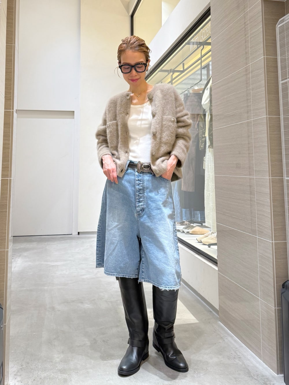 ブルー系のデニムパンツ、ベージュ系のカーディガン/ボレロ、シルバー系のネックレスを着用したレディースの夏コーディネートの6枚目の写真