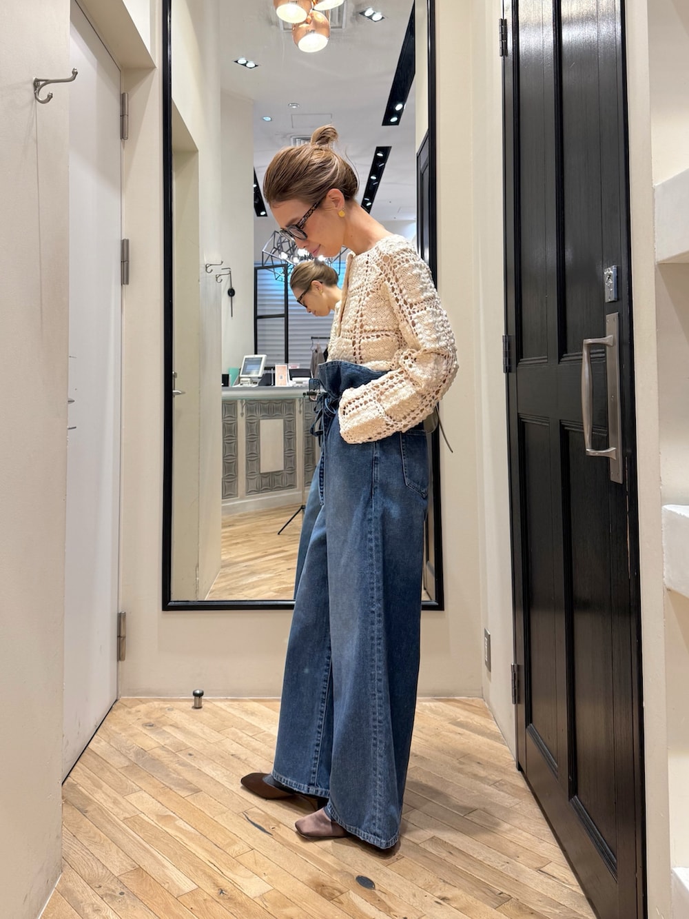 ブルー系のデニムパンツ、ホワイト系のカーディガン/ボレロ、ブラウン系のサンダルを着用したレディースの冬コーディネートの3枚目の写真