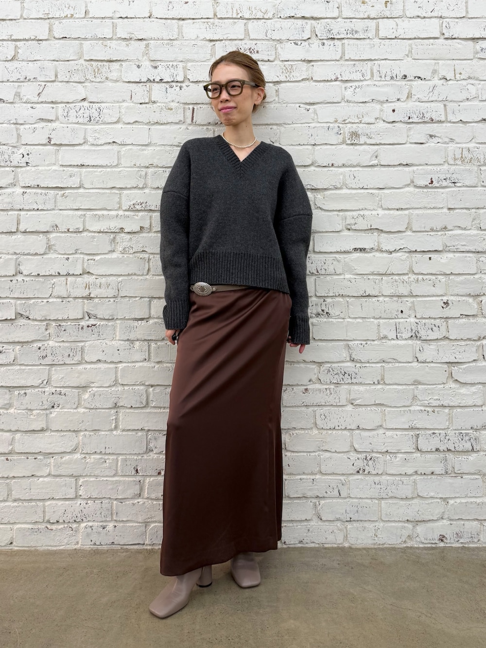 グレー系のブーツ、グレー系のニット/セーター、シルバー系のネックレスを着用したレディースの秋コーディネートの7枚目の写真