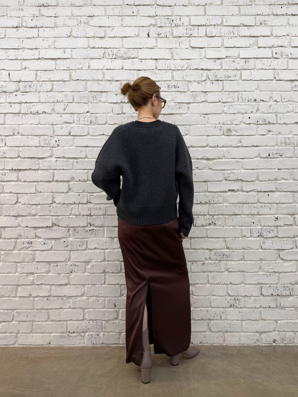 グレー系のブーツ、グレー系のニット/セーター、シルバー系のネックレスを着用したレディースの秋コーディネートの5枚目の写真