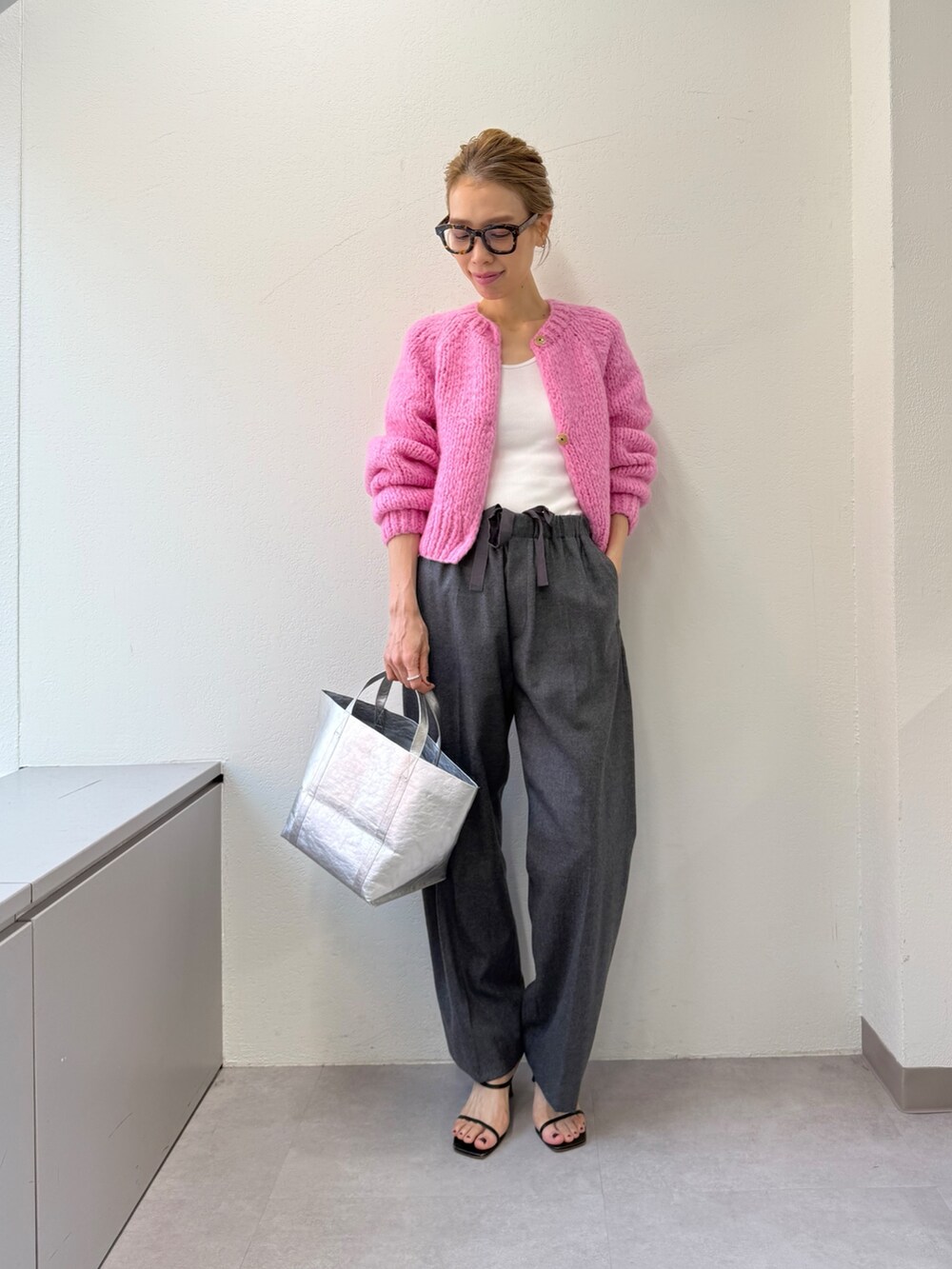 グレー系のその他パンツ、ピンク系のカーディガン/ボレロ、シルバー系のトートバッグを着用したレディースの秋コーディネートの10枚目の写真