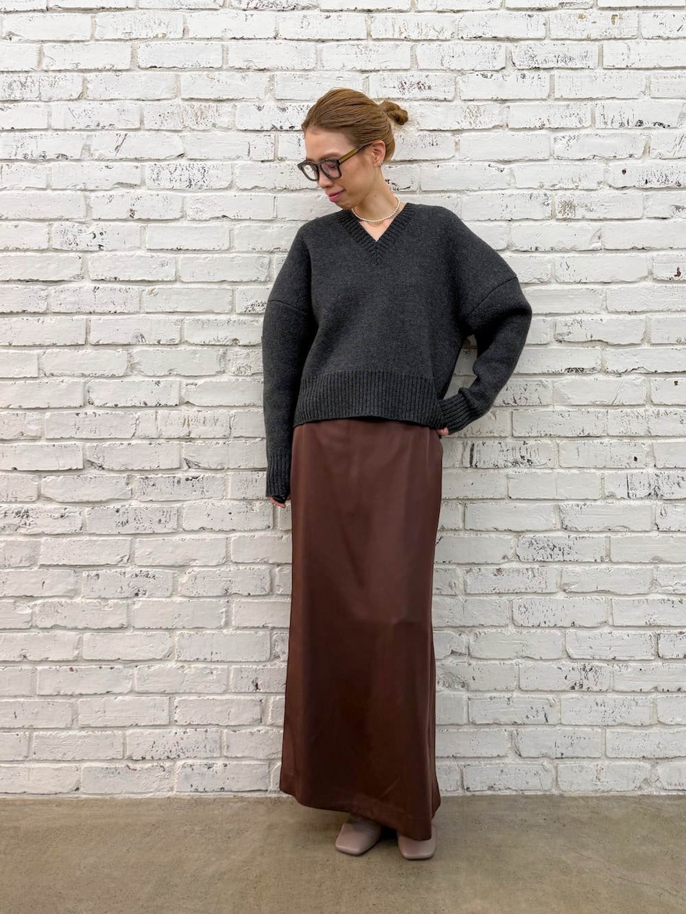 グレー系のブーツ、グレー系のニット/セーター、シルバー系のネックレスを着用したレディースの秋コーディネートの4枚目の写真