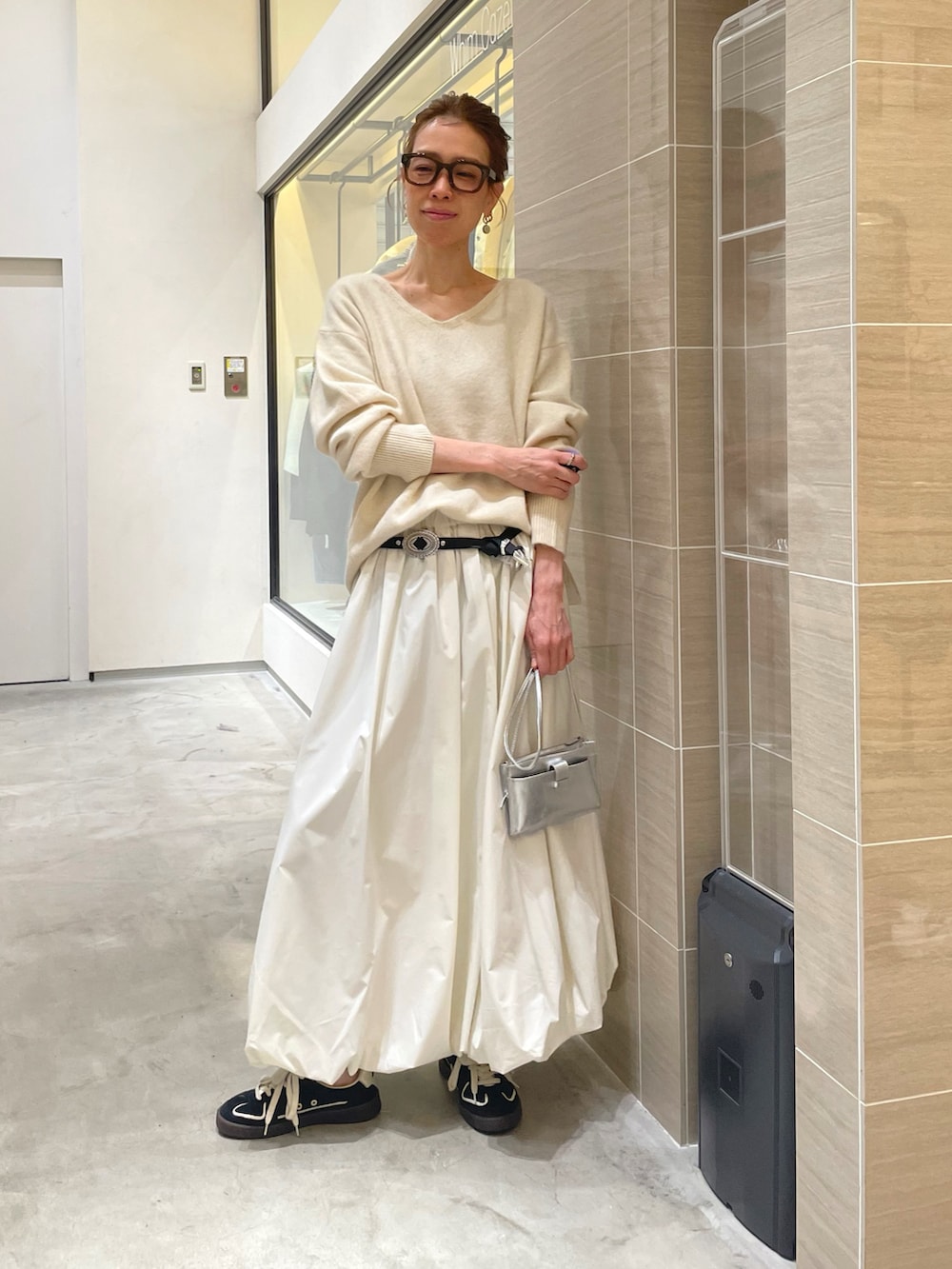 ホワイト系のスカート、ホワイト系のニット/セーター、ブラック系のベルトを着用したレディースの秋コーディネートの7枚目の写真