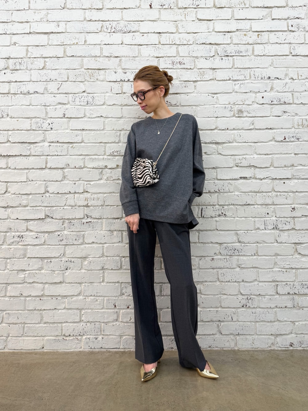 ブラック系のクラッチバッグ、グレー系のTシャツ/カットソー、グレー系のその他パンツを着用したレディースの秋コーディネートの3枚目の写真