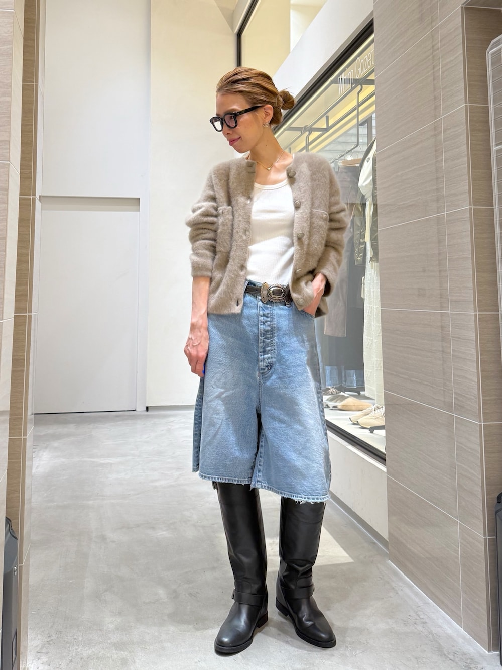 ブルー系のデニムパンツ、ベージュ系のカーディガン/ボレロ、シルバー系のネックレスを着用したレディースの夏コーディネートの7枚目の写真