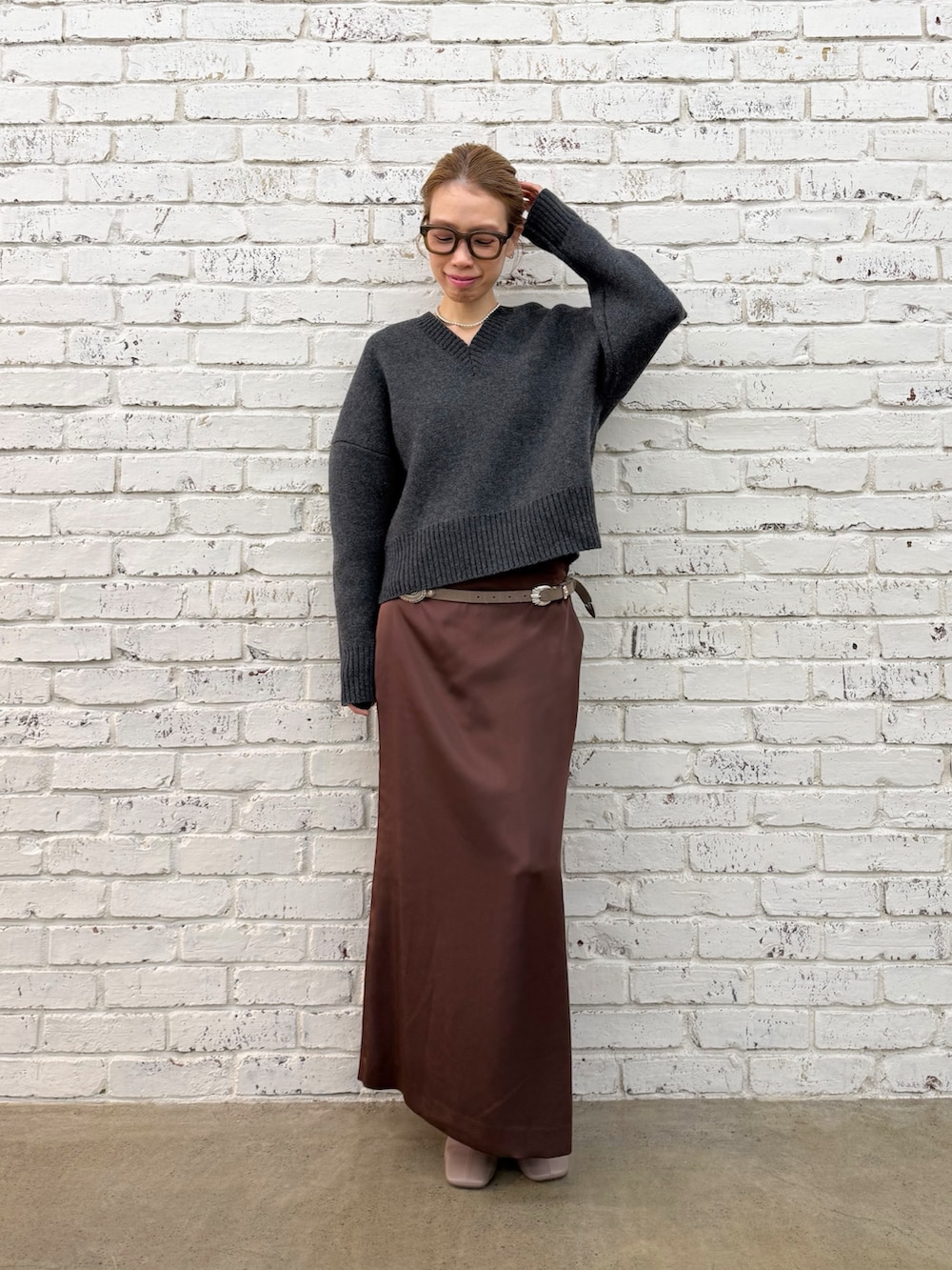 グレー系のブーツ、グレー系のニット/セーター、シルバー系のネックレスを着用したレディースの秋コーディネートの2枚目の写真