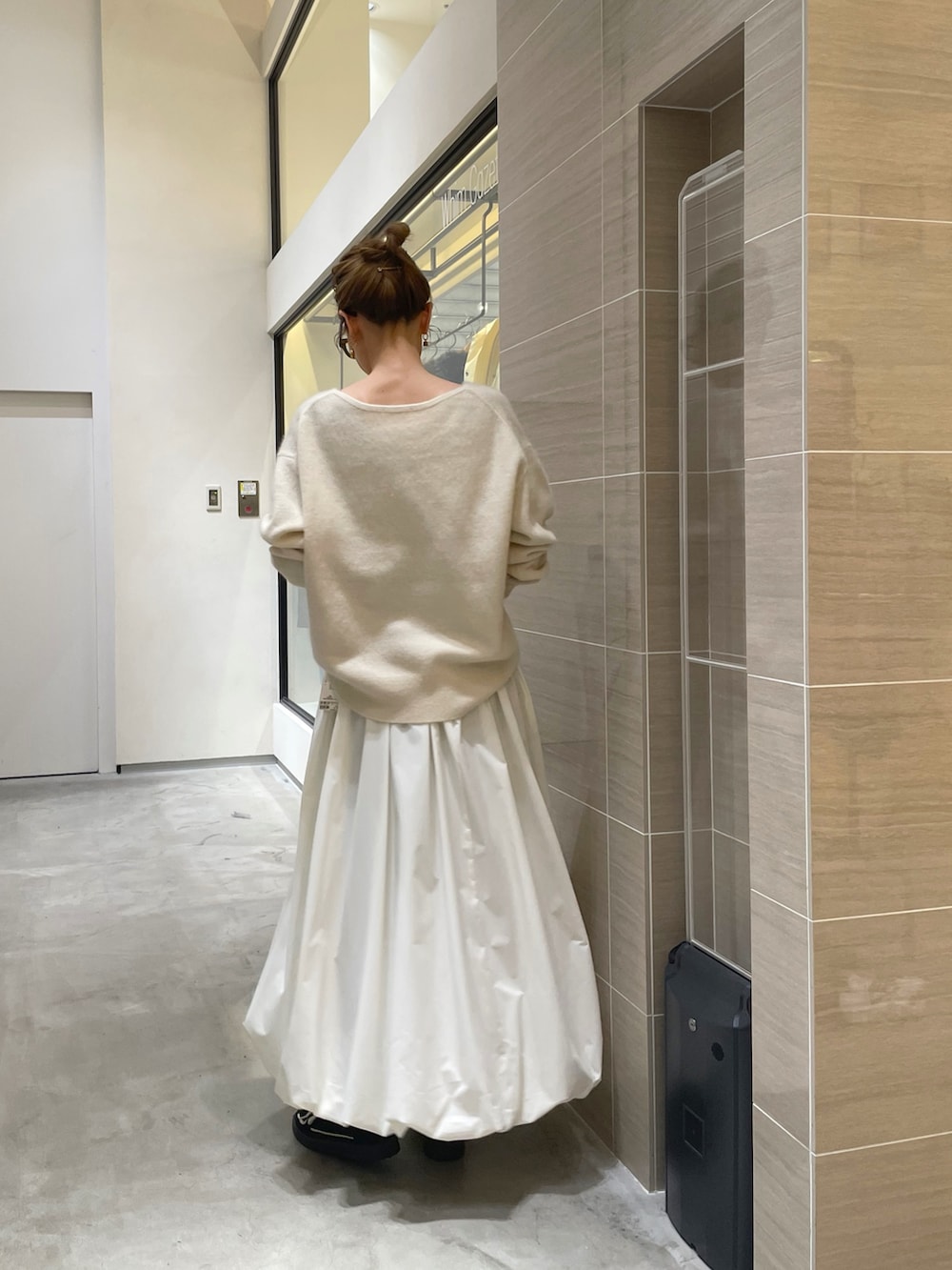 ホワイト系のスカート、ホワイト系のニット/セーター、ブラック系のベルトを着用したレディースの秋コーディネートの3枚目の写真