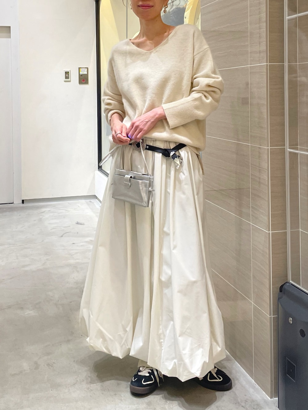 ホワイト系のスカート、ホワイト系のニット/セーター、ブラック系のベルトを着用したレディースの秋コーディネートの8枚目の写真
