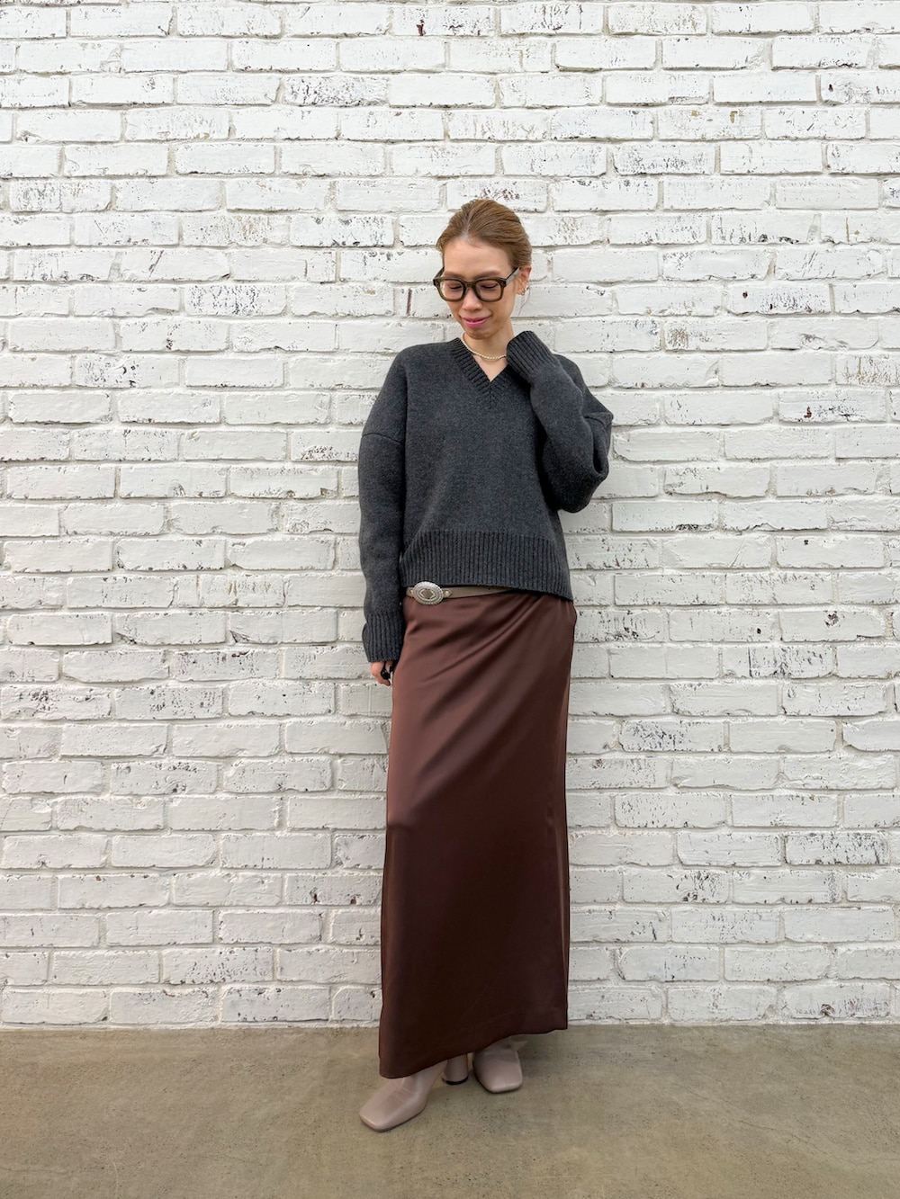 グレー系のブーツ、グレー系のニット/セーター、シルバー系のネックレスを着用したレディースの秋コーディネートの6枚目の写真