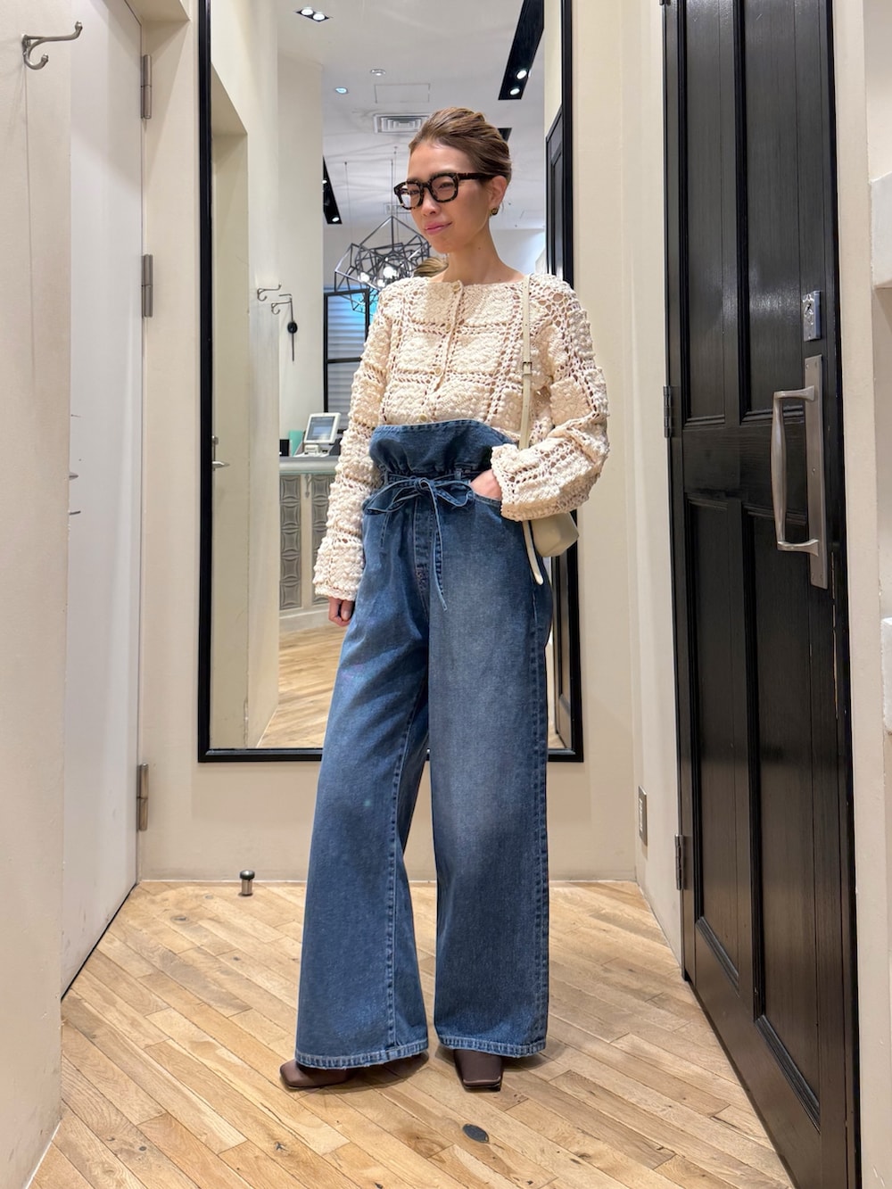 ブルー系のデニムパンツ、ホワイト系のカーディガン/ボレロ、ブラウン系のサンダルを着用したレディースの冬コーディネートの8枚目の写真