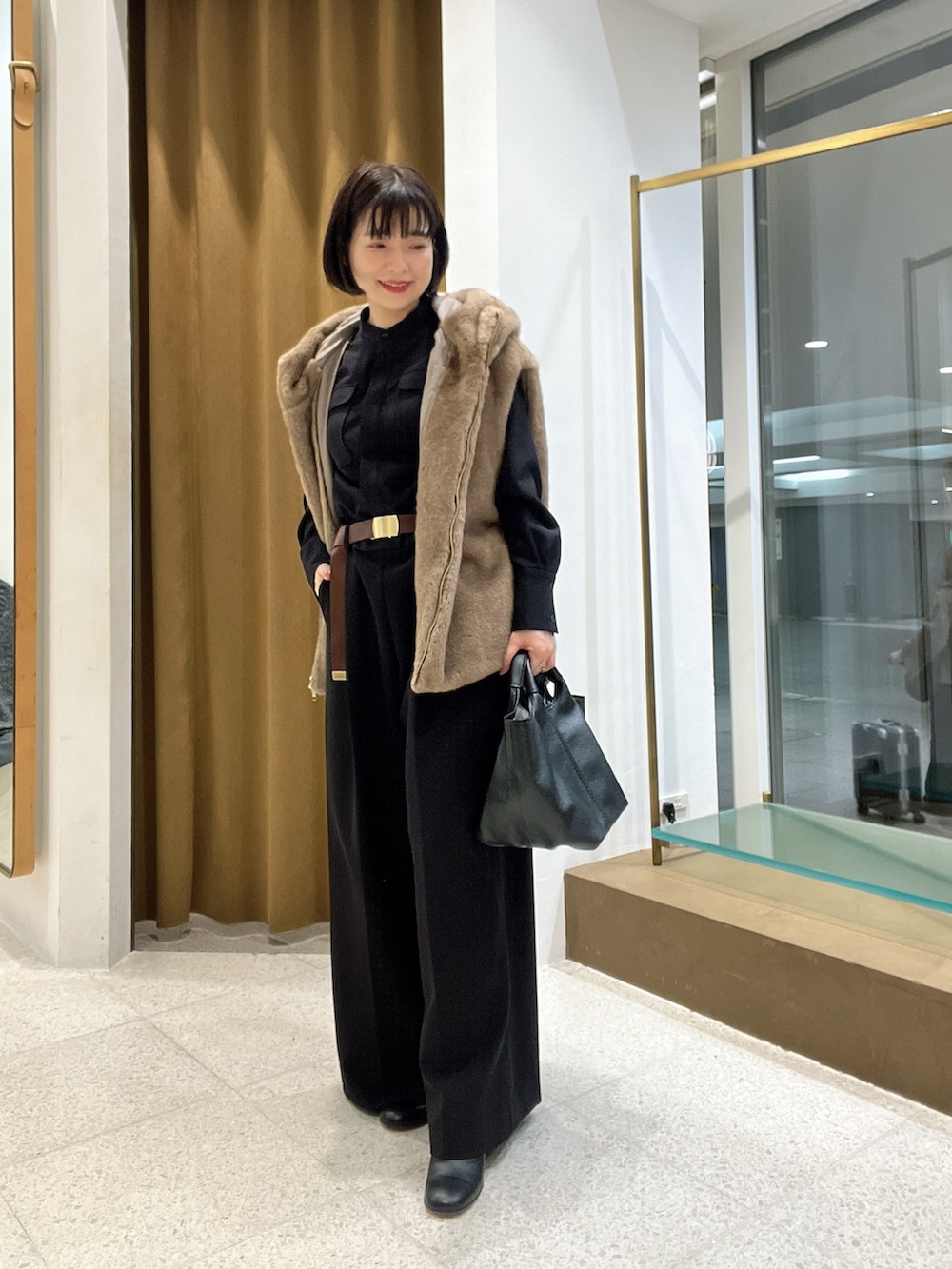 ブラウン系のその他アウター、ブラック系のつなぎ/オールインワン、ブラック系のトートバッグを着用したレディースの秋コーディネートの5枚目の写真