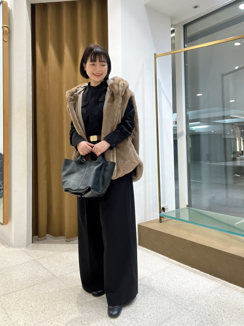 ブラウン系のその他アウター、ブラック系のつなぎ/オールインワン、ブラック系のトートバッグを着用したレディースの秋コーディネートの4枚目の写真