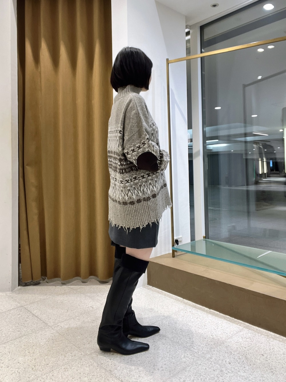 ベージュ系のニット/セーター、グレー系のスカート、ブラック系のボストンバッグを着用したレディースの秋コーディネートの4枚目の写真