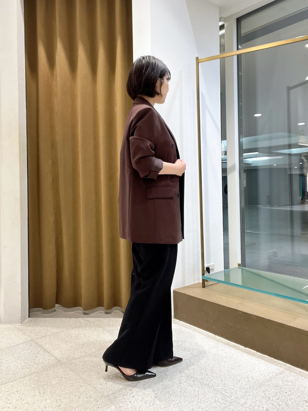 ブラウン系のテーラードジャケット、ブラウン系のショルダーバッグ、ブラウン系のパンプスを着用したレディースの秋コーディネートの3枚目の写真