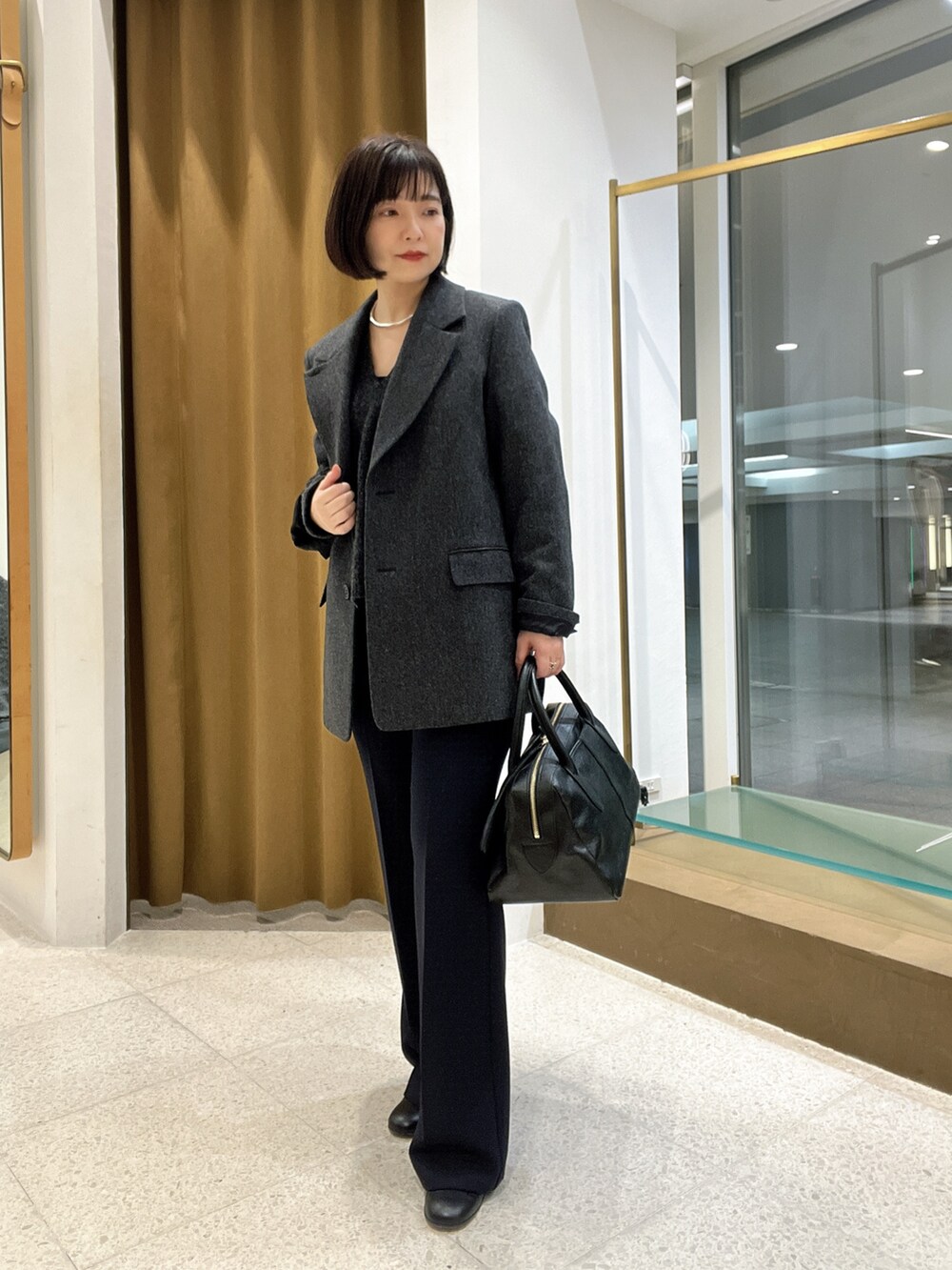 グレー系のテーラードジャケット、グレー系のニット/セーター、ブラック系のトートバッグを着用したレディースの秋コーディネートの5枚目の写真