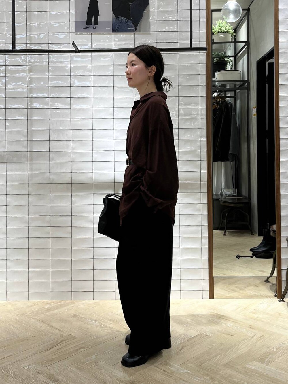 ブラック系のスラックス、ブラウン系のシャツ/ブラウス、ブラック系のベルトを着用したレディースの秋コーディネートの2枚目の写真