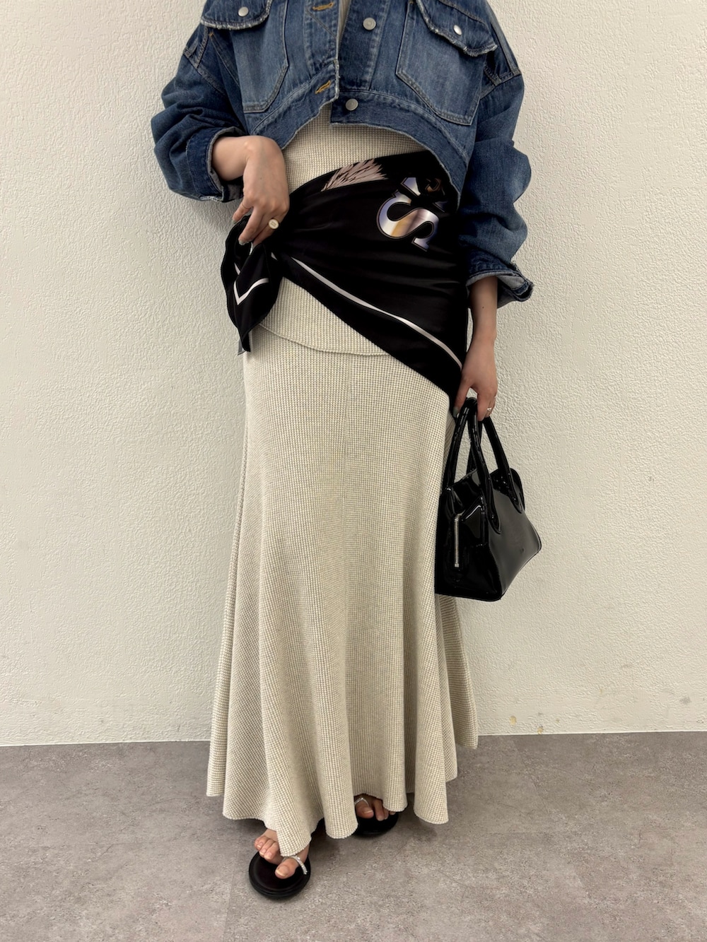 ブルー系のデニムジャケット、ベージュ系のTシャツ/カットソー、ベージュ系のスカートを着用したレディースの春コーディネートの4枚目の写真