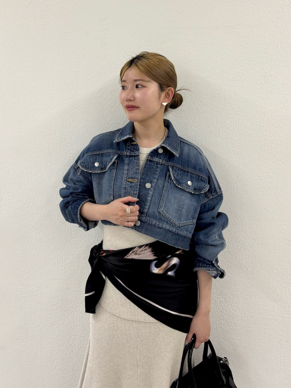 ブルー系のデニムジャケット、ベージュ系のTシャツ/カットソー、ベージュ系のスカートを着用したレディースの春コーディネートの3枚目の写真