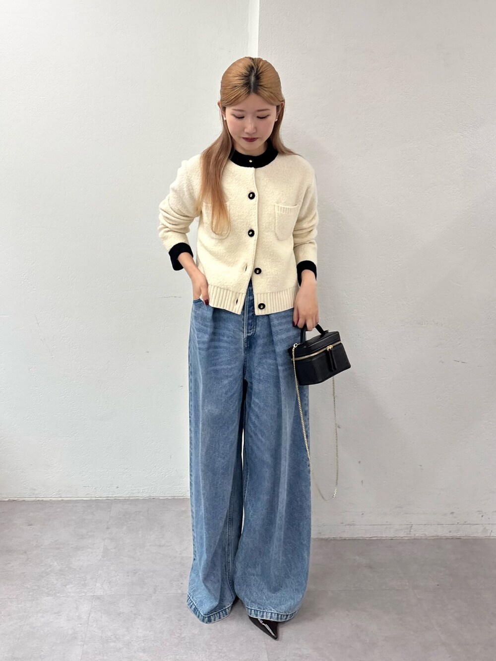 ホワイト系のカーディガン/ボレロ、ブルー系のデニムパンツ、ブラウン系のパンプスを着用したレディースの秋コーディネートの4枚目の写真