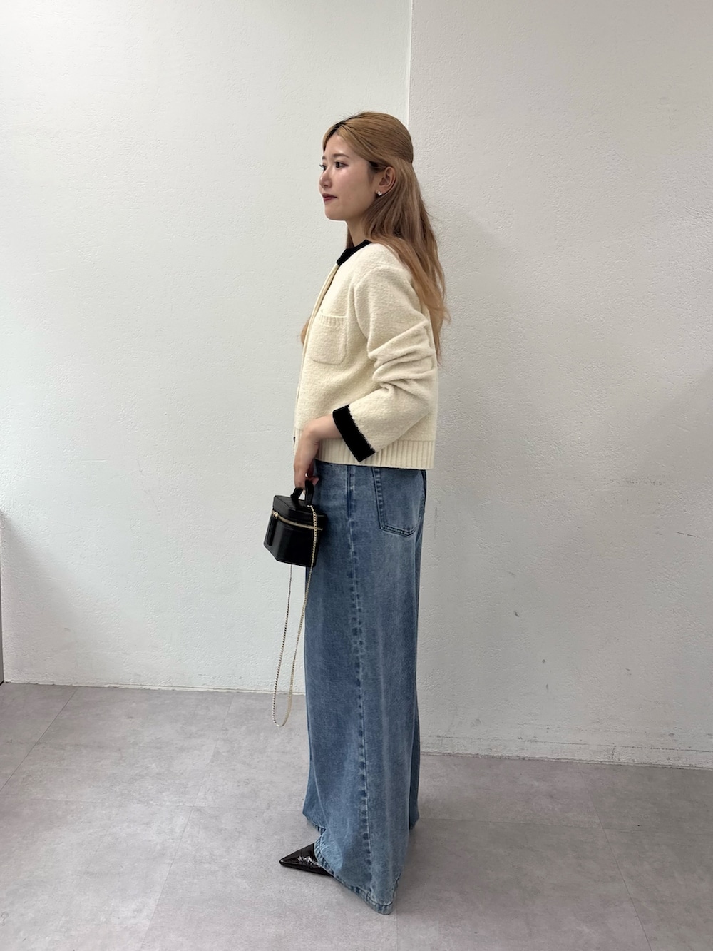 ホワイト系のカーディガン/ボレロ、ブルー系のデニムパンツ、ブラウン系のパンプスを着用したレディースの秋コーディネートの2枚目の写真