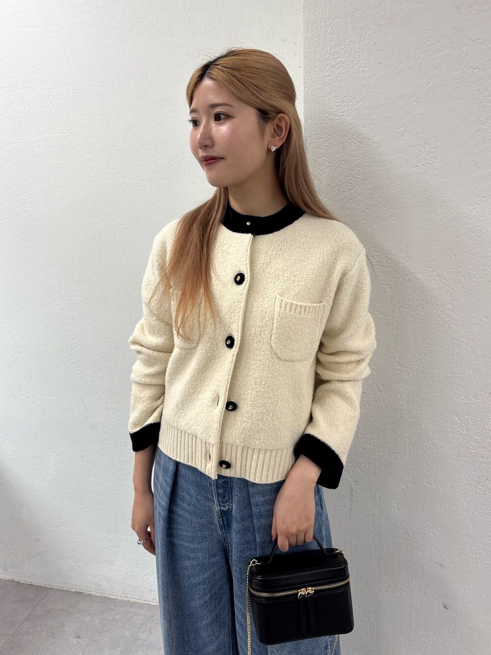 ホワイト系のカーディガン/ボレロ、ブルー系のデニムパンツ、ブラウン系のパンプスを着用したレディースの秋コーディネートの3枚目の写真