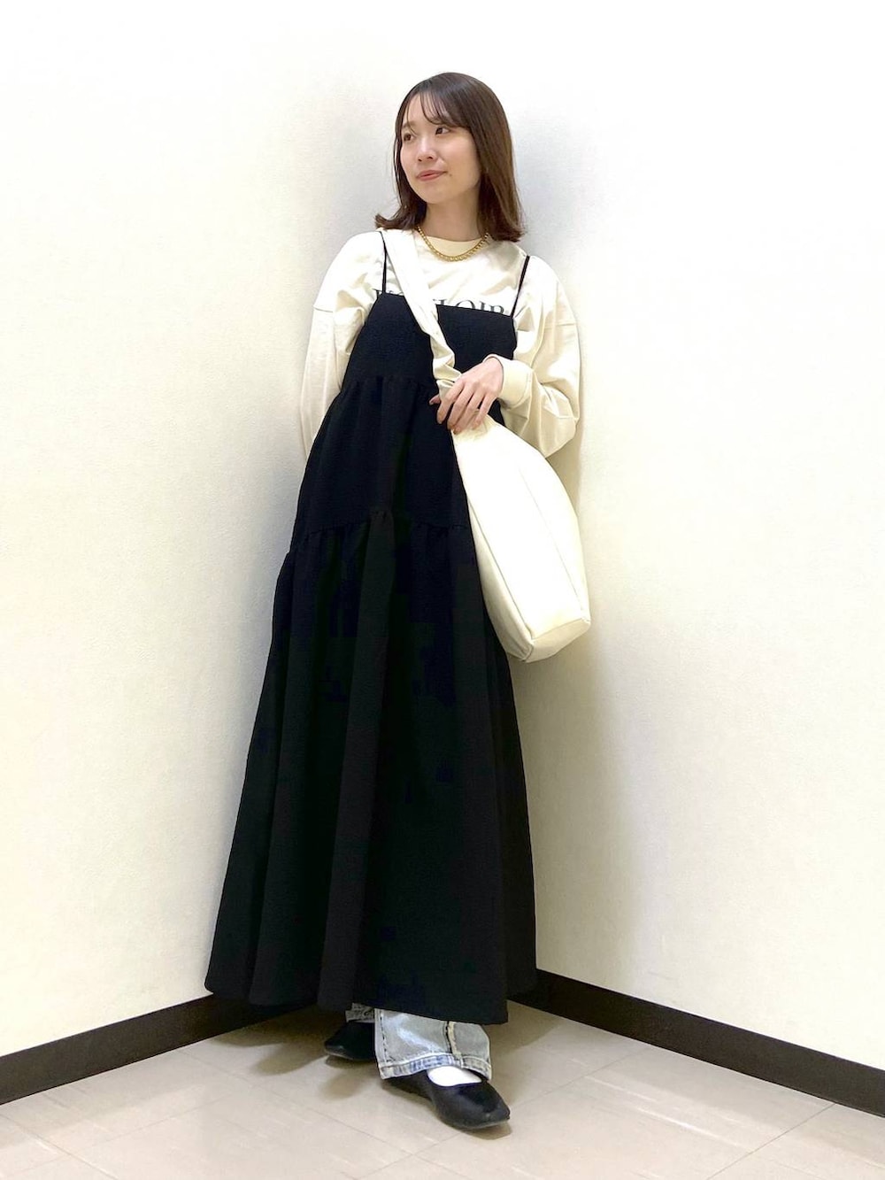 ベージュ系のトートバッグ、ブラック系のパンプス、ブルー系のデニムパンツを着用したレディースの春コーディネートの2枚目の写真