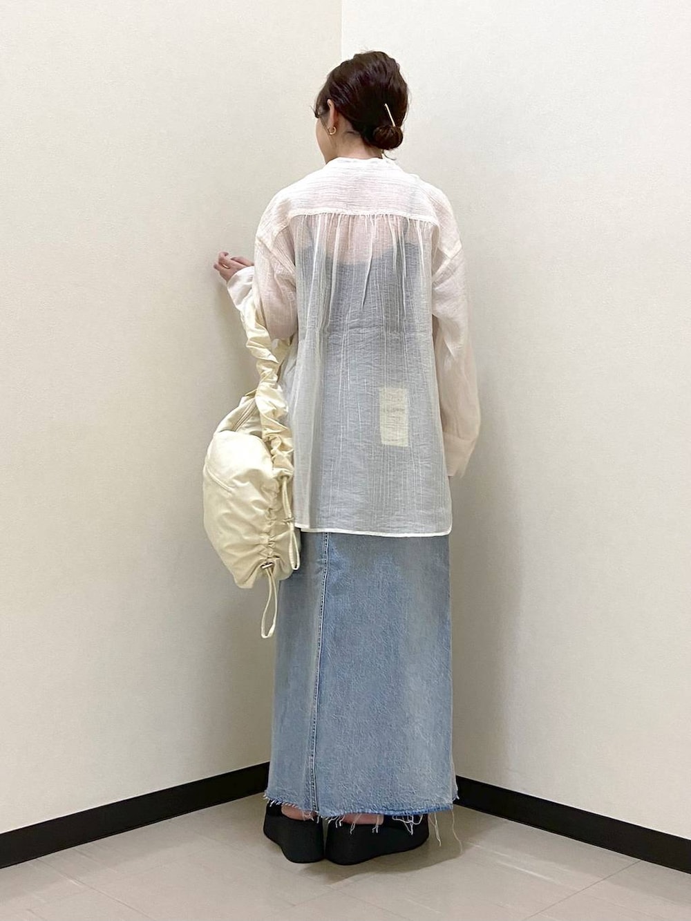 ブラック系のサンダル、ホワイト系のショルダーバッグ、ブルー系のスカートを着用したレディースの春コーディネートの3枚目の写真