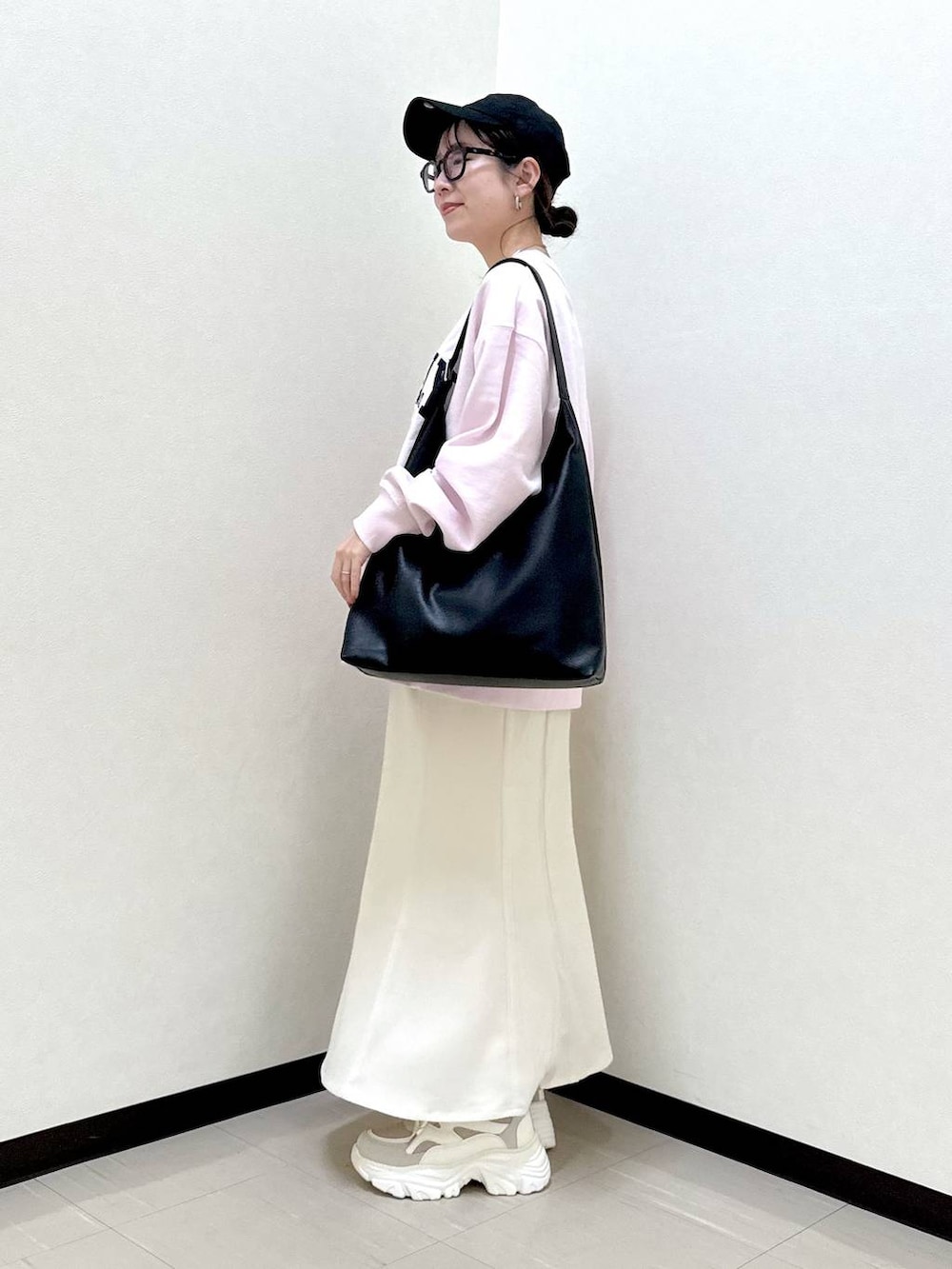 ブラック系のショルダーバッグ、ベージュ系のスニーカー、ピンク系のスウェットを着用したレディースの冬コーディネートの2枚目の写真