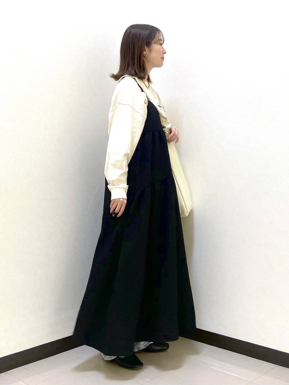 ベージュ系のトートバッグ、ブラック系のパンプス、ブルー系のデニムパンツを着用したレディースの春コーディネートの5枚目の写真