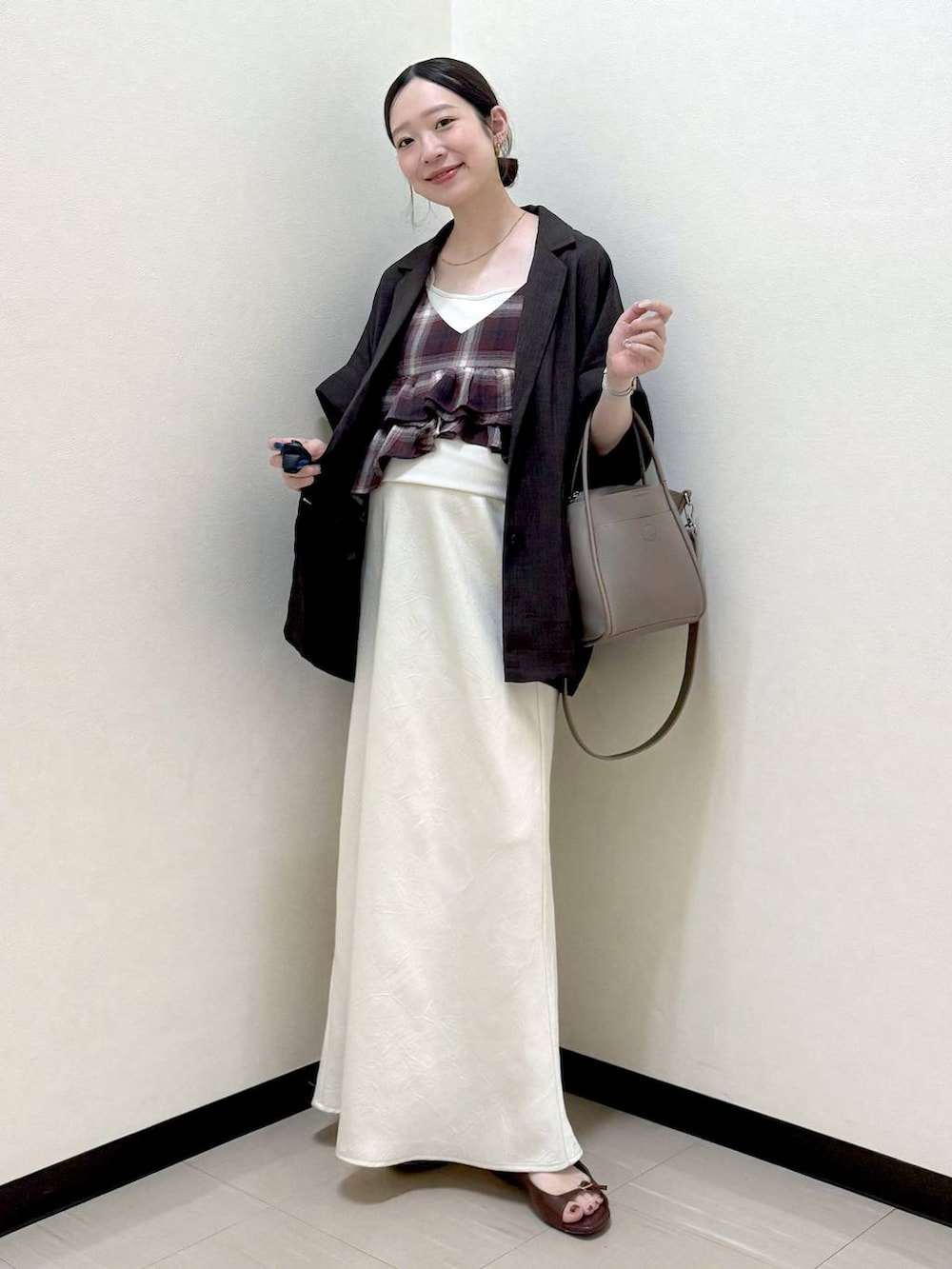 ホワイト系のTシャツ/カットソー、ホワイト系のスカート、ブラック系のテーラードジャケットを着用したレディースの夏コーディネートの2枚目の写真