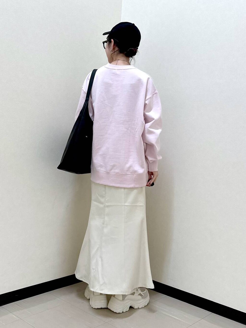 ブラック系のショルダーバッグ、ベージュ系のスニーカー、ピンク系のスウェットを着用したレディースの冬コーディネートの3枚目の写真