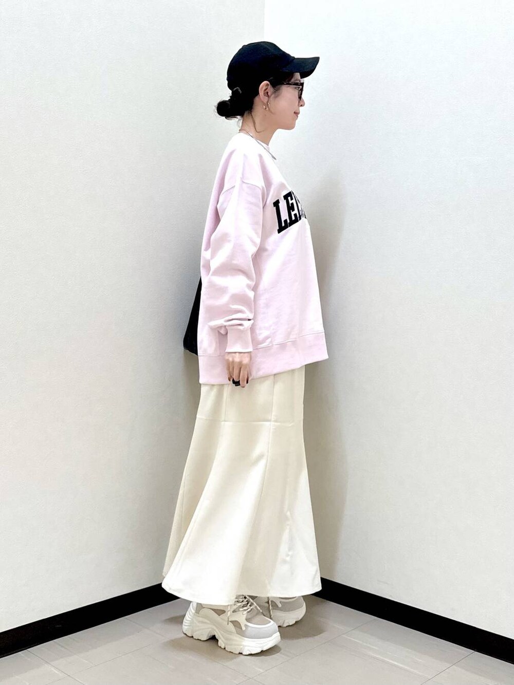 ブラック系のショルダーバッグ、ベージュ系のスニーカー、ピンク系のスウェットを着用したレディースの冬コーディネートの4枚目の写真