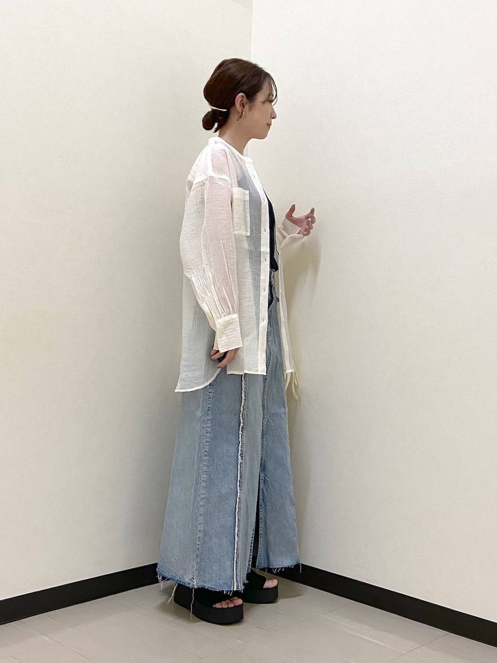 ブラック系のサンダル、ホワイト系のショルダーバッグ、ブルー系のスカートを着用したレディースの春コーディネートの2枚目の写真