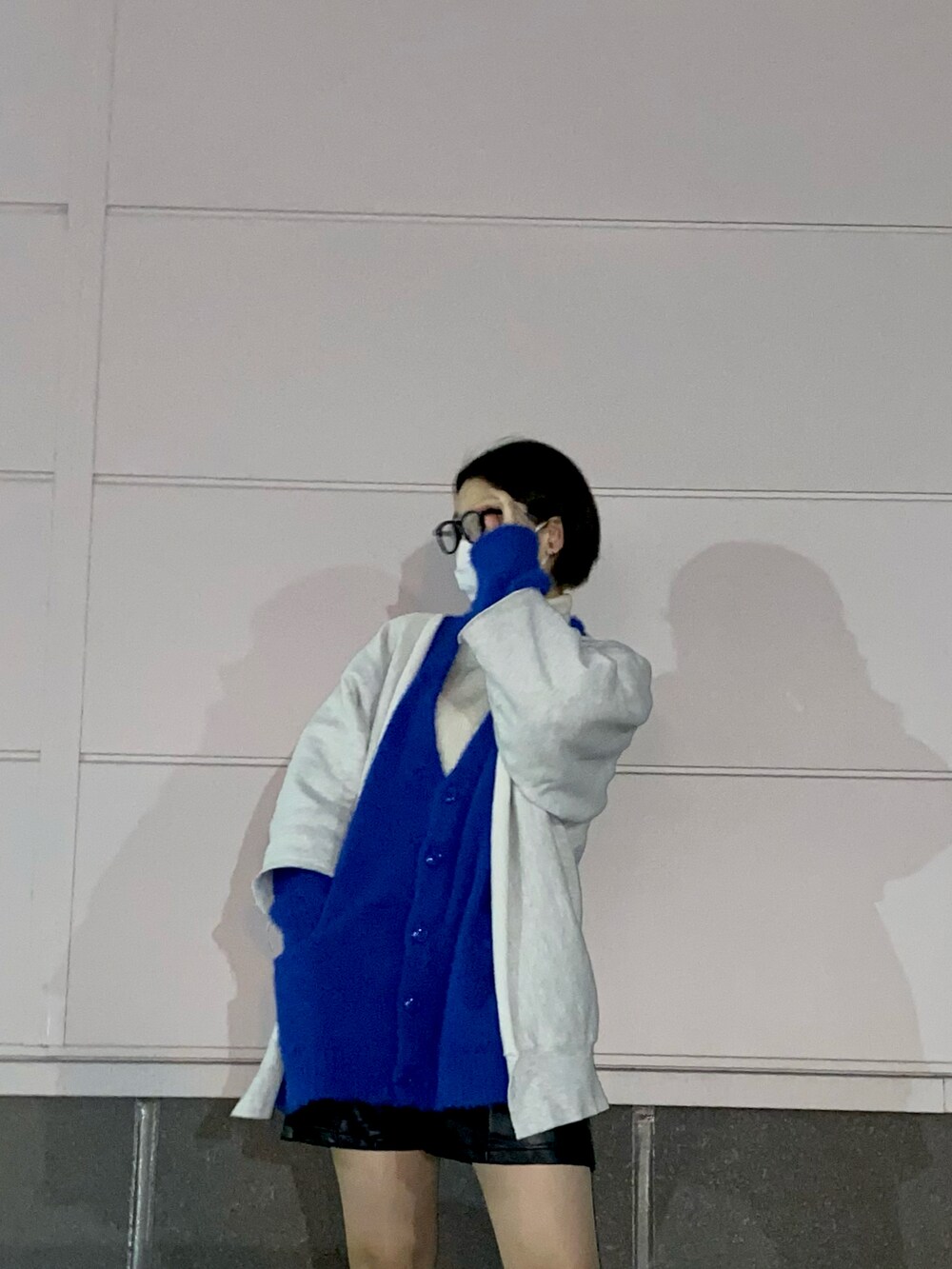 ブルー系のカーディガン/ボレロ、ブラック系のブーツ、ブラック系のメガネを着用したレディースの春コーディネートの3枚目の写真