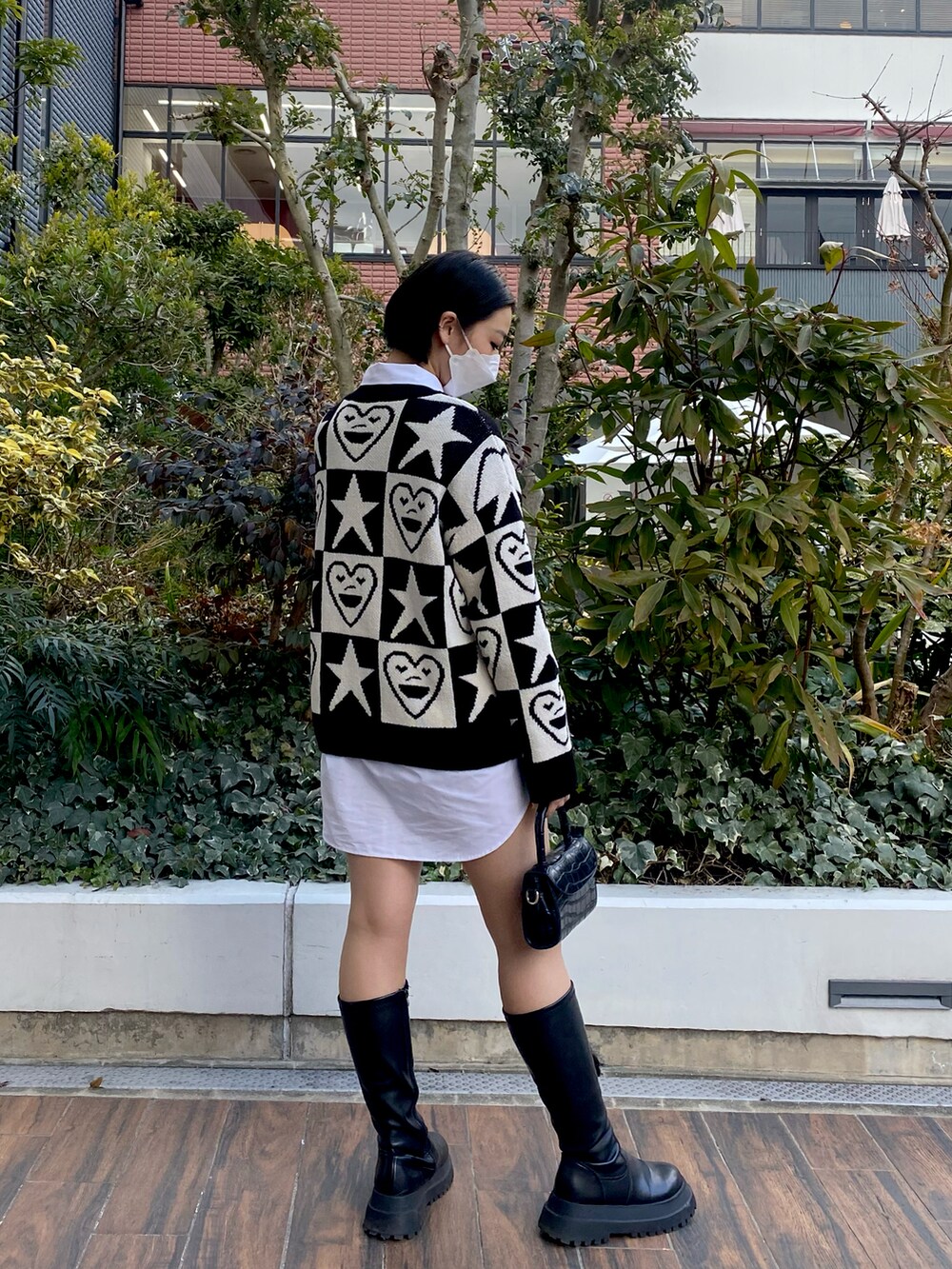 ブラック系のニット/セーター、ブラック系のブーツ、ブラック系のハンドバッグを着用したレディースの春コーディネートの3枚目の写真