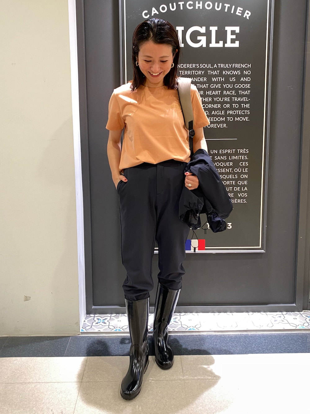 ブラック系のノーカラージャケット、ピンク系のTシャツ/カットソー、ブラック系のチノパンツを着用したレディースの春コーディネートの4枚目の写真