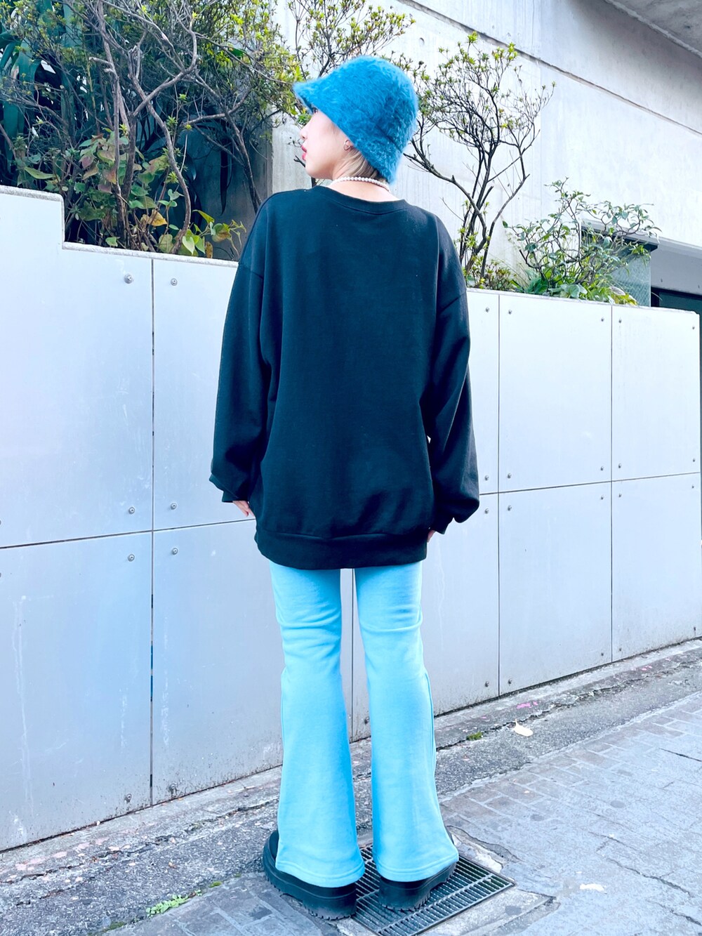 ブラック系のスウェット、ブルー系のスウェットパンツ、ブラック系のブーツを着用したレディースの秋コーディネートの2枚目の写真