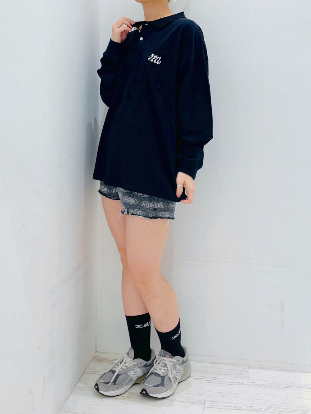 ブラック系のデニムパンツ、ブラック系のポロシャツを着用したレディースの春コーディネートの4枚目の写真