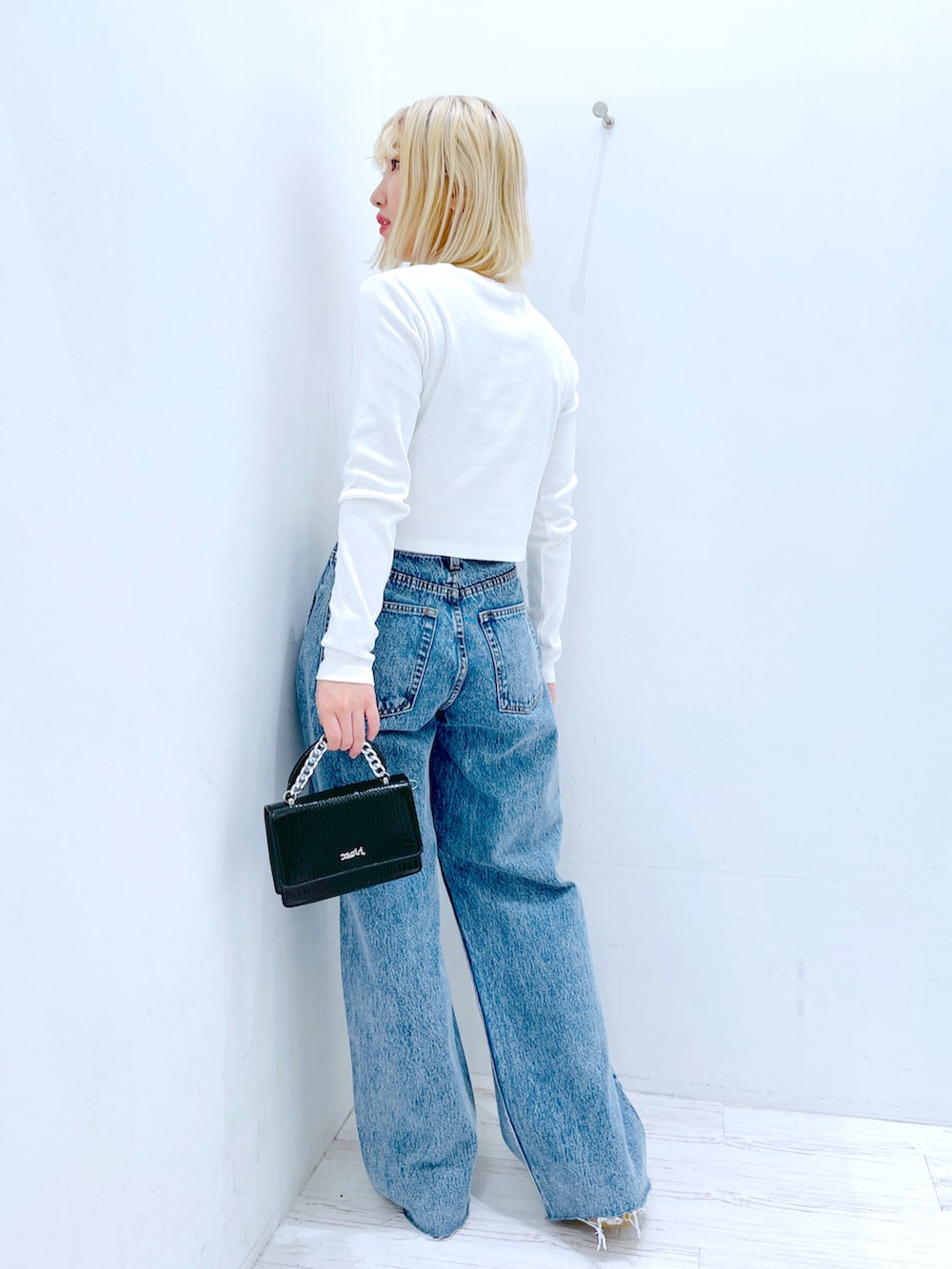 ホワイト系のTシャツ/カットソー、ブルー系のデニムパンツ、ブラック系のショルダーバッグを着用したレディースの春コーディネートの3枚目の写真
