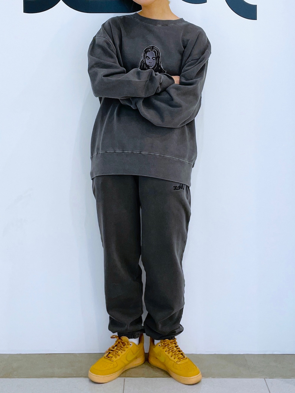 グレー系のスウェット、ブラック系のスウェットパンツ、ブラック系のハットを着用したレディースの冬コーディネートの2枚目の写真