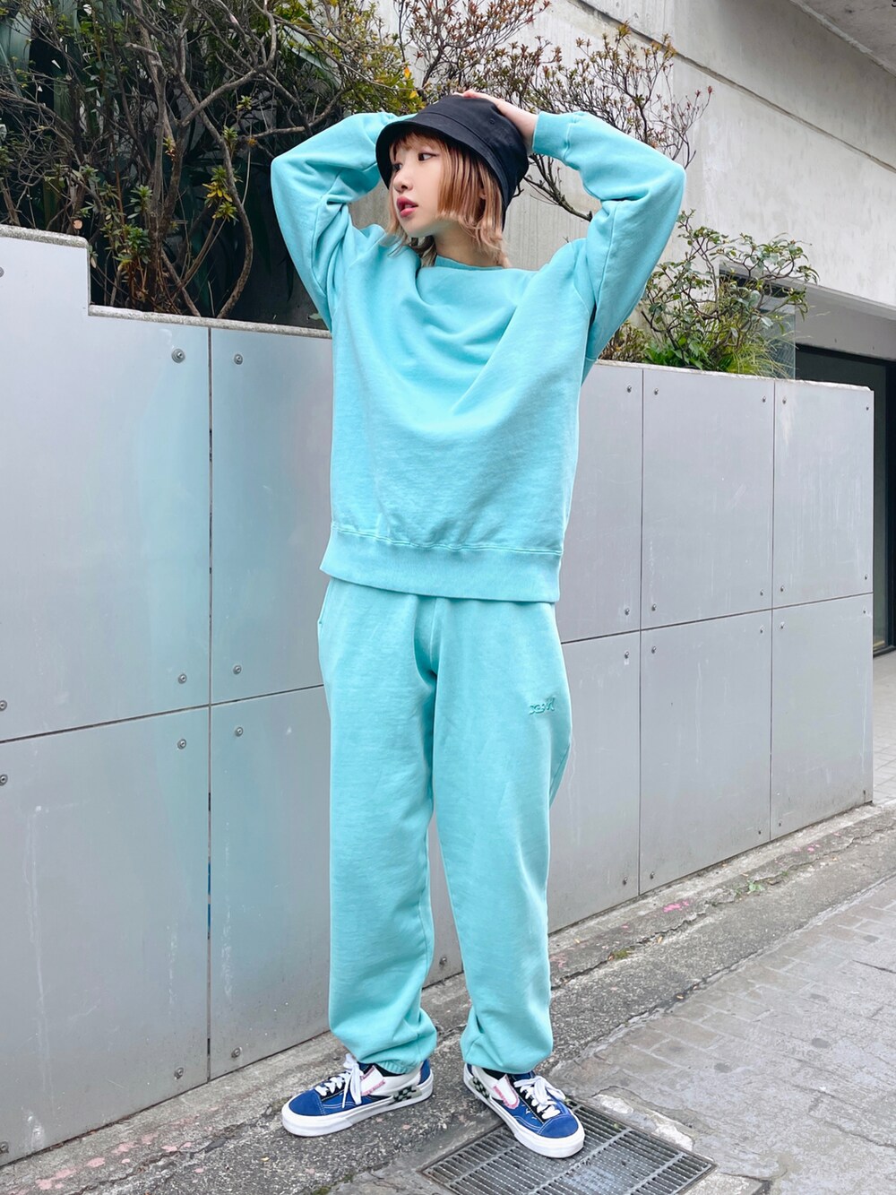 グリーン系のスウェット、グリーン系のスウェットパンツ、ブラック系のハットを着用したレディースの冬コーディネートの2枚目の写真