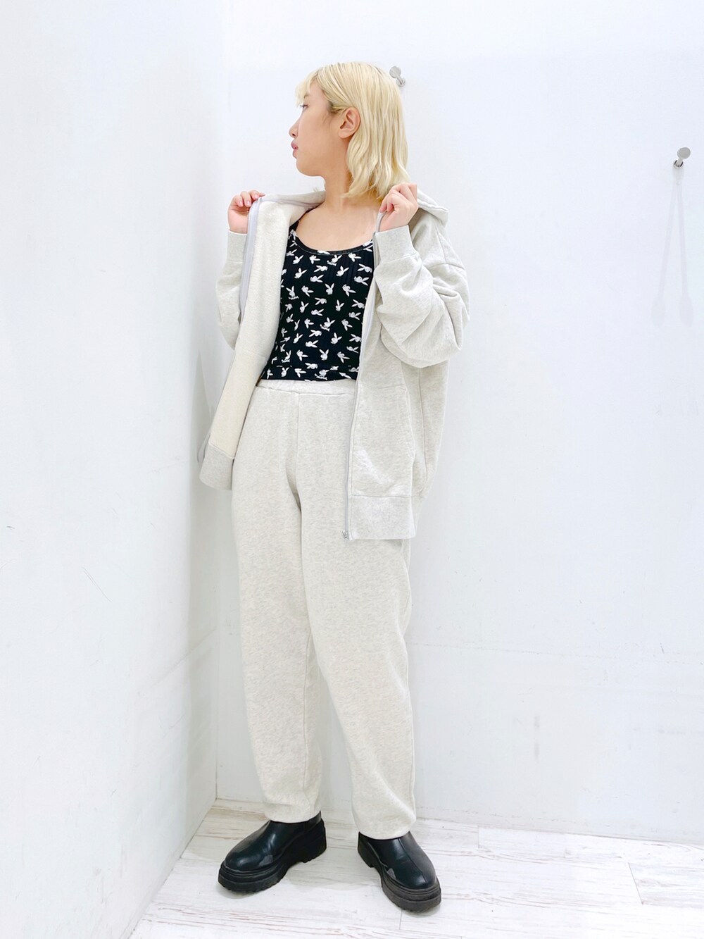 ブラック系のスウェットパンツ、ブラック系のキャミソール、グレー系のパーカーを着用したレディースの春コーディネートの2枚目の写真