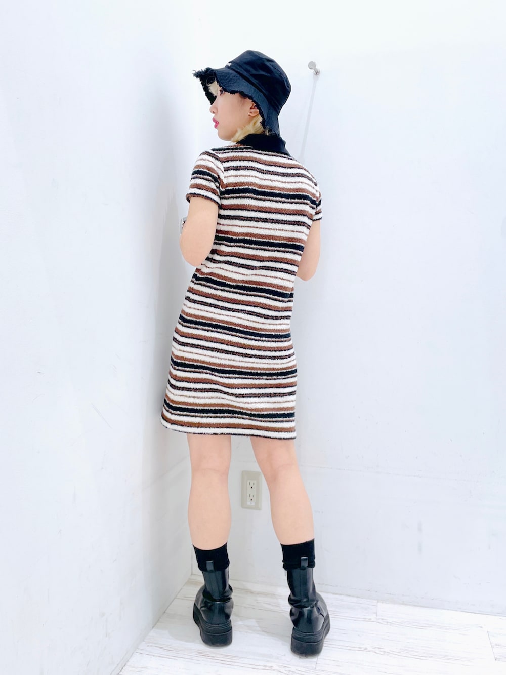 ホワイト系のワンピース、ブラック系のハットを着用したレディースの春コーディネートの2枚目の写真