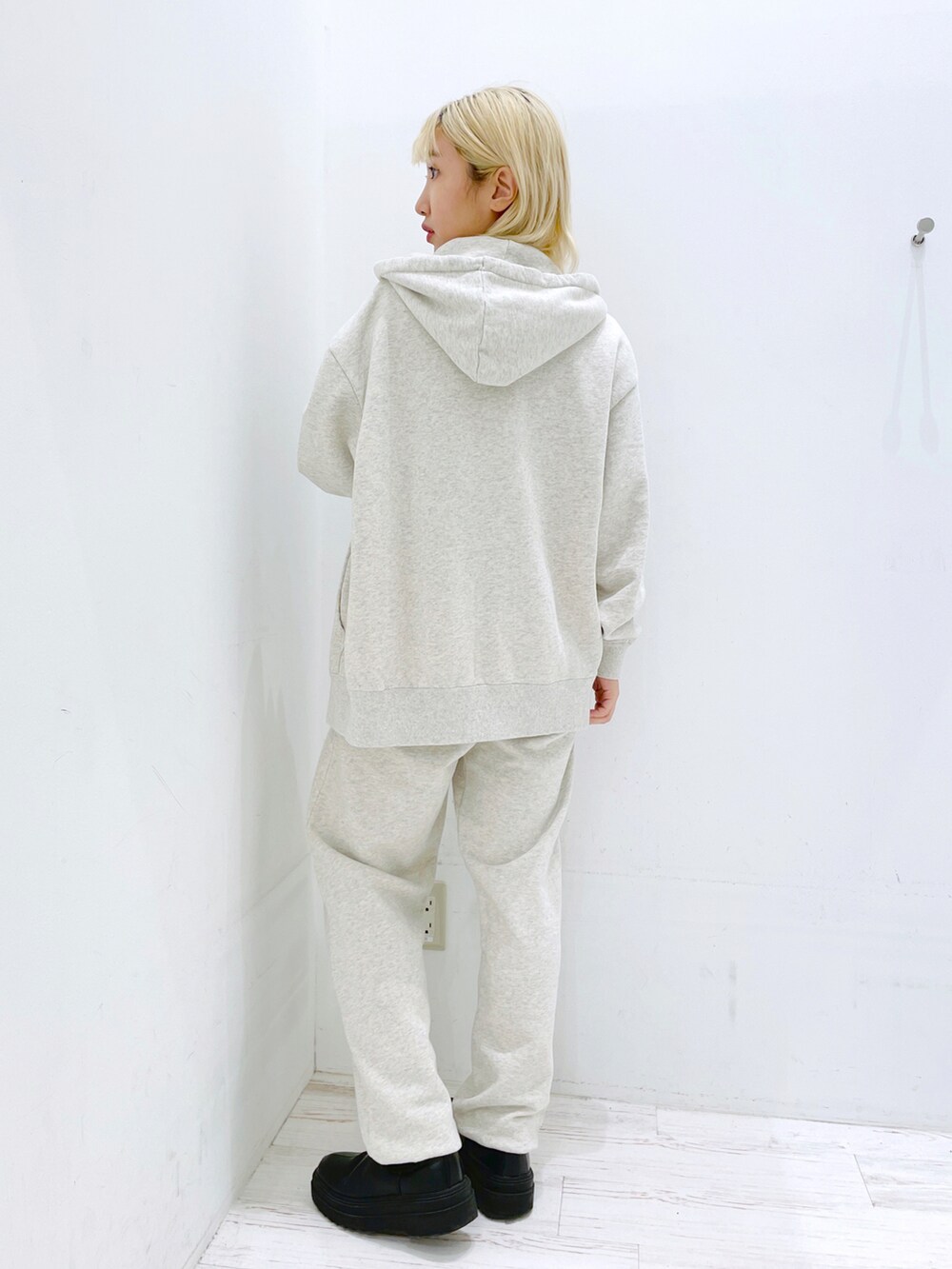 ブラック系のスウェットパンツ、ブラック系のキャミソール、グレー系のパーカーを着用したレディースの春コーディネートの3枚目の写真