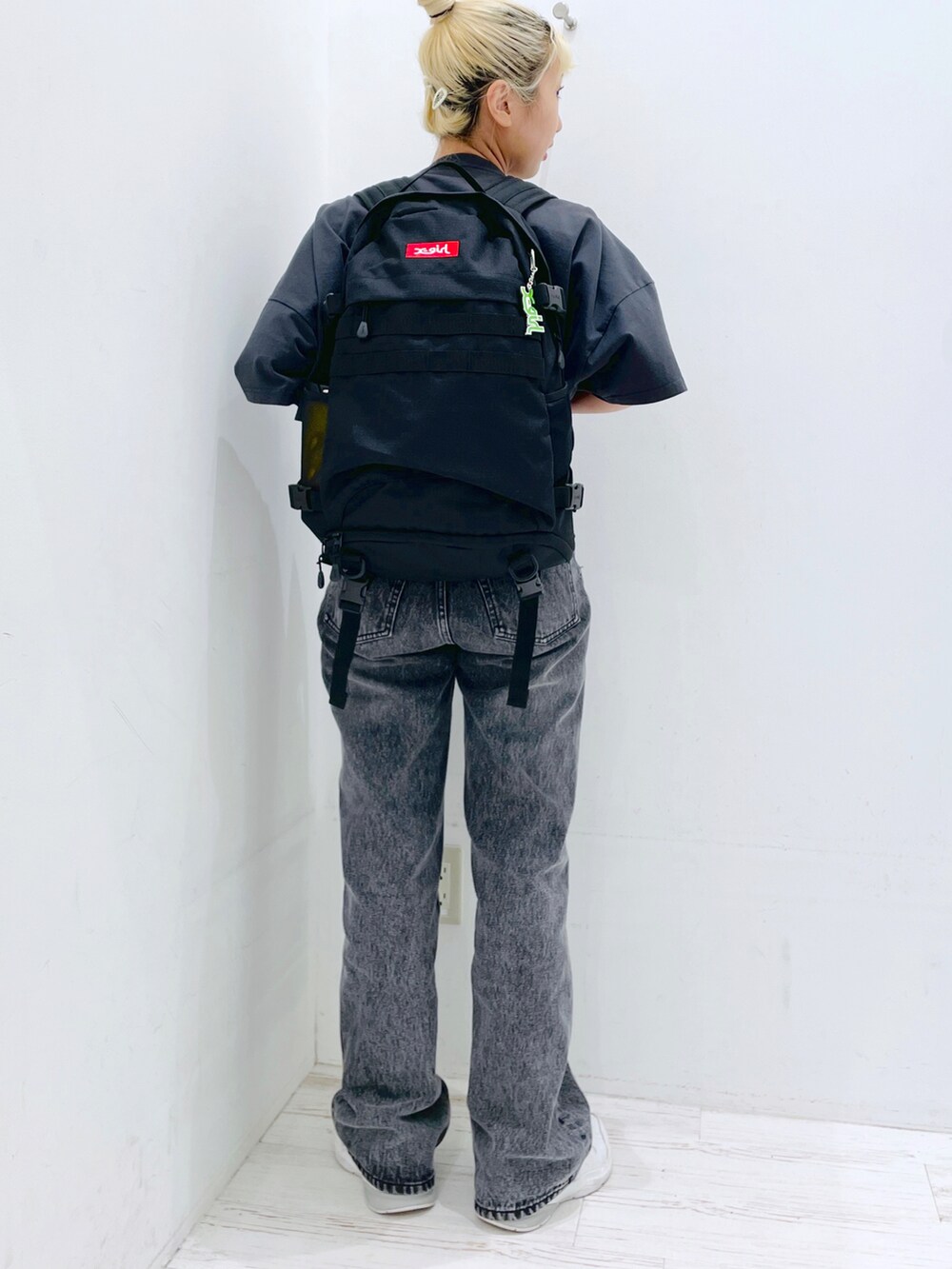 ブラック系のデニムパンツ、レッド系のバックパック/リュック、イエロー系のグラス/マグカップ/タンブラーを着用したレディースの春コーディネートの2枚目の写真