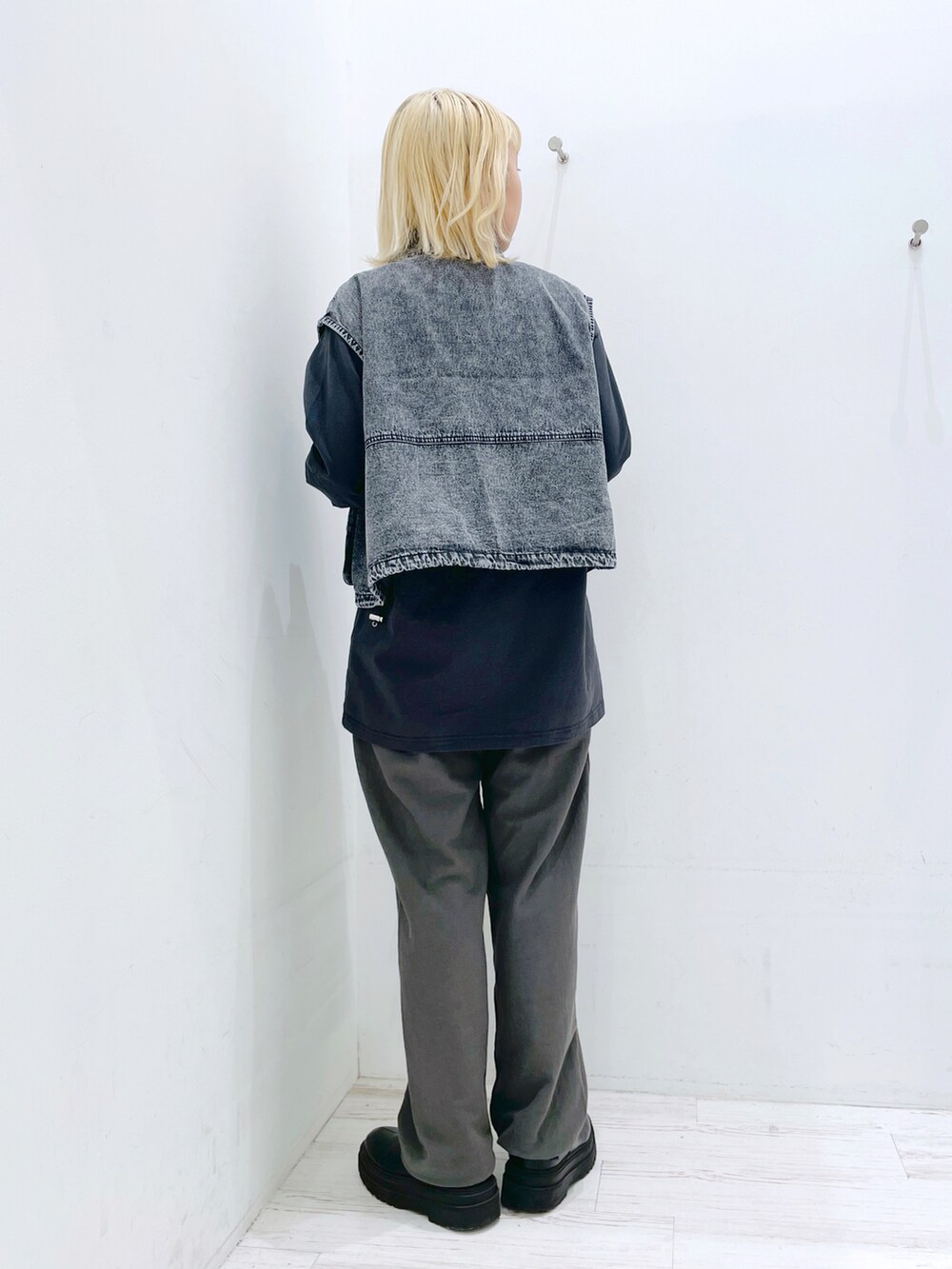 ブラック系のスウェットパンツ、ブラック系のベスト、グレー系のTシャツ/カットソーを着用したレディースの春コーディネートの3枚目の写真