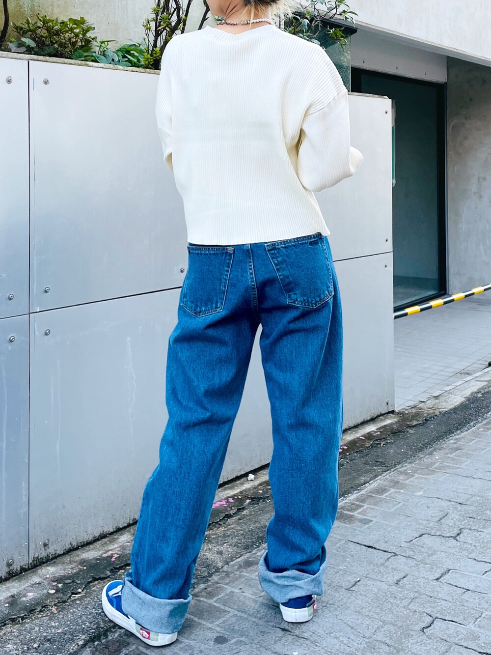 ブルー系のデニムパンツ、ホワイト系のニット/セーター、ブラック系のブルゾンを着用したレディースの秋コーディネートの5枚目の写真